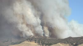 huge plume with coloful smoke on mountainside at