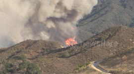 huge flames on mountain with hikers at