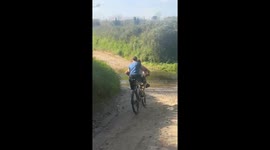 Two boys fall into water while riding bicycle in Riudellots de la Selva, Spain