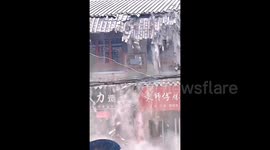 Strong winds rip tiles off building roof seeing them cascade like snow
