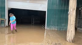 Raw video footage of Garrett Hamilton, Frankfort Kentucky, cleaning up inches of mud left by the Kentucky river in his business named Garrett's golf garage.