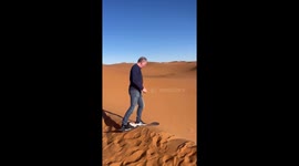 Person falls while sliding down sand dune in Merzouga