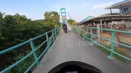 Terrifying motorbike ride along narrow bridge in Thailand