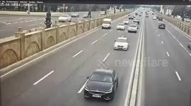 Car crashes through barrier and lands on busy road