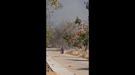 Dust devil tornado whips up leaves in front of motorcycle rider