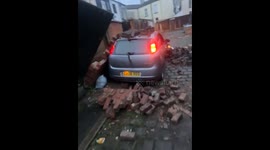 Car Waits For Mate Under Fallen Brick Pile
