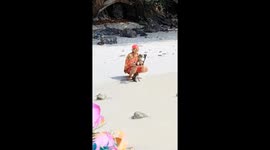 Wild monkeys play with tourists on beach in Thailand