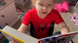 Confident toddler accidentally swears while pretending to read a book