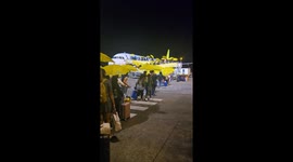Passengers given yellow umbrellas to board plane during drizzle