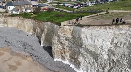 Vistors to Birling Gap, UK  walk close to the edge of the crumbling cliffs