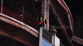 A Team Of Construction Workers Seen Removing A Window Frame From A High Rise