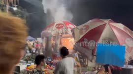 Tourists use water guns to extinguish fire at fried chicken stall in Thailand