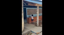 Schoolgirl balances ice cream cone in mouth as she washes hands