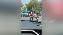 Food delivery rider dances while waiting at junction