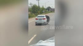 Car drives with cargo sticking out of door