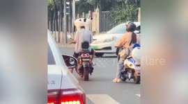 Pet cat sits on motorcycle riders shoulders