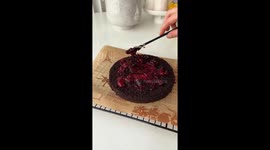 Talented baker prepares fudgy chocolate cake with mascarpone frosting and wild berry jam