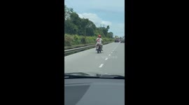 Motorcycle with wobbly wheel crawls along road