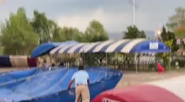 Marquees blown away by sudden gusts crash into building