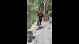 Person surfs on inner city river in Hangzhou with hydrofoil board
