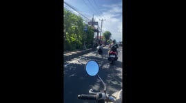 Wheelchair user races motorcycles as he speeds along road in Bali