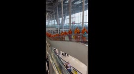Buddhist holiday! Dozens of monks ride escalator at airport