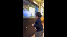 Child startled by fish at aquarium in Guangdong