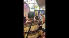 Priest in the Philippines uses water hose to give final blessing