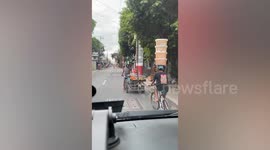 Bread vendor balances stack of plastic containers on his head