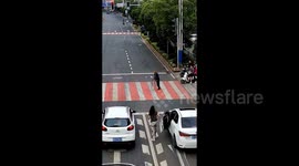 Kind-hearted driver gets out car to help elderly man cross busy street in China