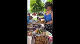 Kind mother shares picnic with struggling family sitting nearby