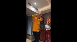 Person balances on unicycle while cutting noodle dough with head