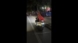 Golden Retriever in pyjamas rides pillion on electric scooter
