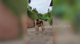 Man holds plank by balancing on four 4.5ft high brick towers in impressive stunt