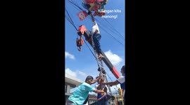 Men rescue helium balloons stuck on phone lines