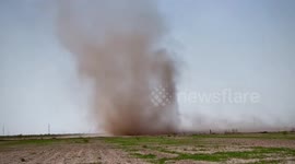 Dust devil grows and sweeps across field in Saragosa, Texas, USA