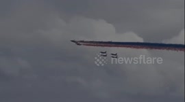 The Red Arrows perform a London flyby in front of a dramatic stormy sky for VE Day celebrations