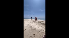 Beachgoers use bamboo pole as giant selfie-stick for drone-like video