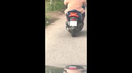 Motorist drives on road with liquor bottle on his head