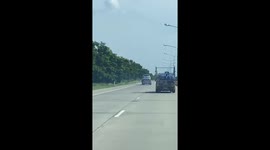 Flames seen coming from under tow truck carrying broken-down car