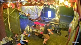 Food seller battles to hold up tent as storm hits street in China
