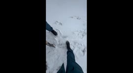 Three people jump on snow, one falls