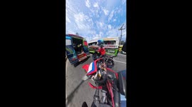 Motorcycle rider hops onto back of bus to avoid heat of sun