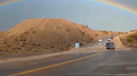 US: Rainbow Shines Over Flooded Road in Mojave Desert