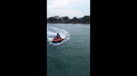 Couple try posing on jet ski only to topple into the sea