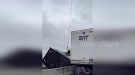 Trucker lifted to safety as vehicle hangs from the edge of highway