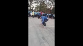 Schoolboys play amusing game walking on bricks across playground