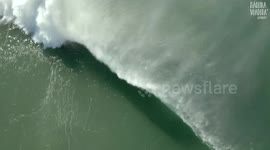 Beautiful aerial shot of a wave engulfing a surfer