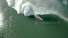 Beautiful aerial shot of a wave engulfing a surfer