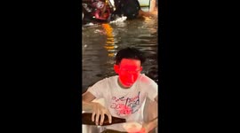 Local drifts on old bathtub around flooded streets in Bangkok